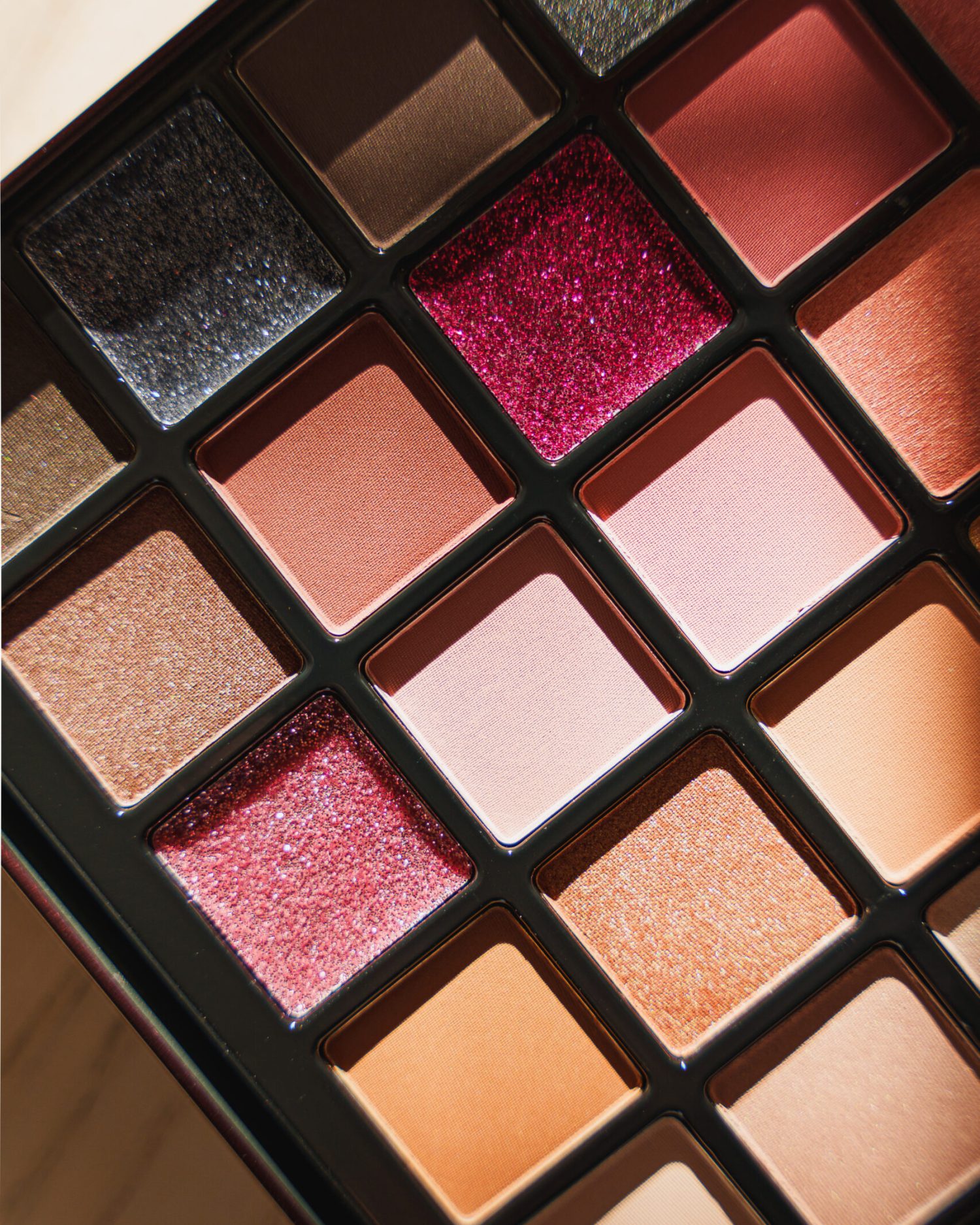 Minuit studio brand photography Minuit studio brand photography - Close up on an eye shadows make-up palette in warm tones including a game with light and shadows